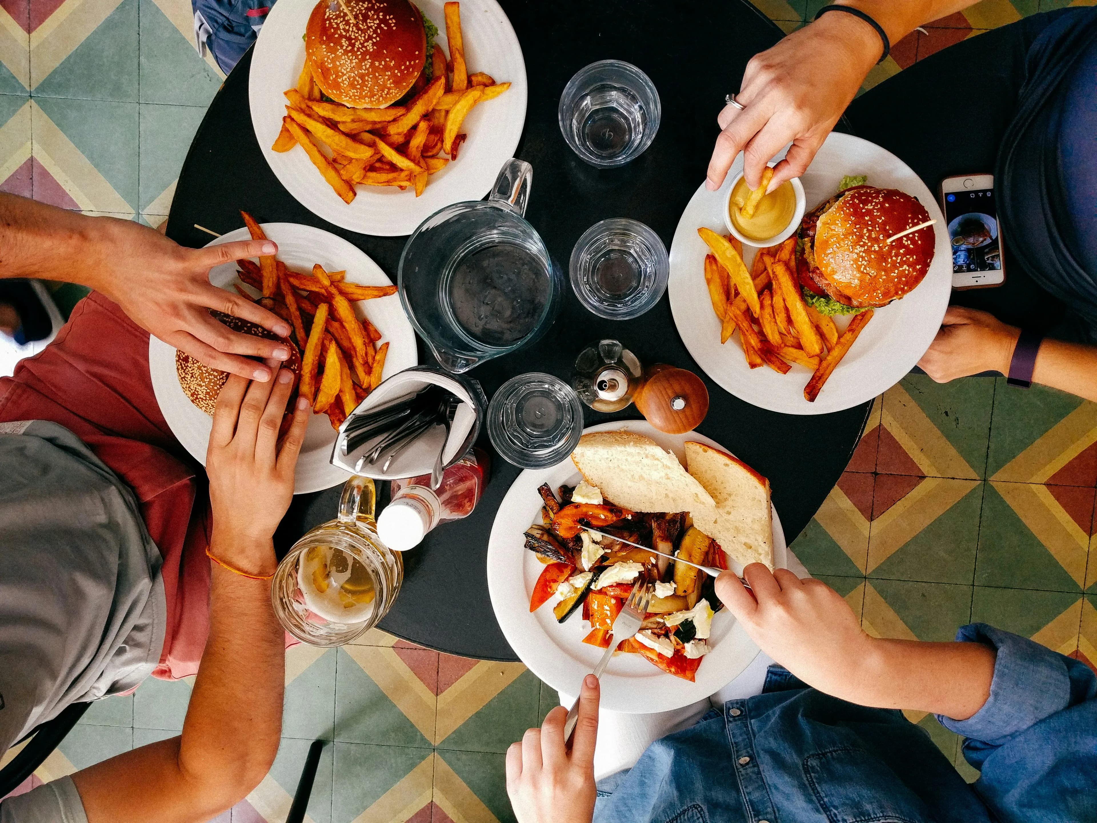 Gäste teilen Burger und Fritten am Tisch